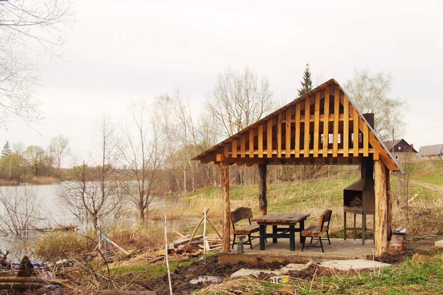 Беседка с мангалом на берегу пруда.